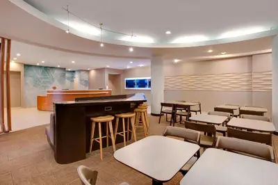 a restaurant with a bar and tables and chairs at SpringHill Suites Hartford Airport/Windsor Locks in Windsor Locks