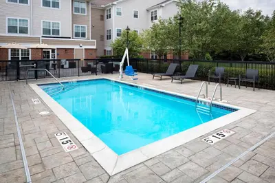 a swimming pool in a courtyard with a building at Residence Inn Milford in Milford