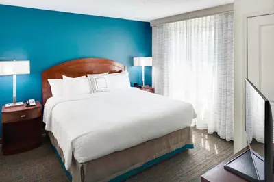 a bedroom with a large bed and a blue wall at Residence Inn Milford in Milford
