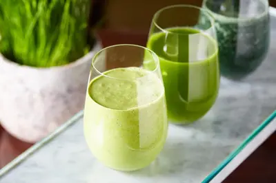 two glasses of green juice sitting on a table at Four Seasons Hotel New York in New York