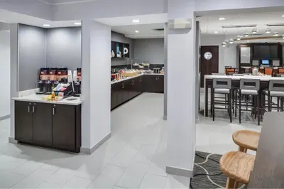 a kitchen and dining room with a counter and a bar at SpringHill Suites Milford in Milford