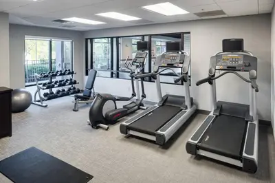 a gym with treadmills and ellipticals in a room at SpringHill Suites Milford in Milford