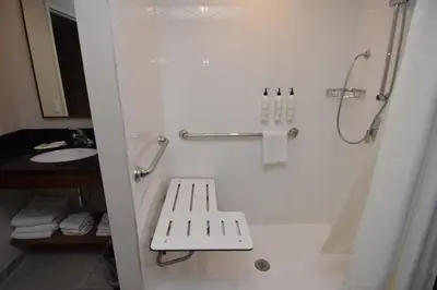 a bathroom with a shower with a bench in it at Fairfield Inn by Marriot Binghamton in Binghamton