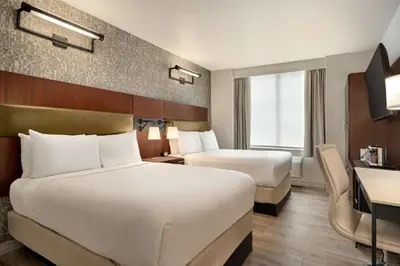 a hotel room with two beds and a desk at DoubleTree by Hilton New York Downtown in New York
