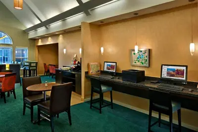 a hotel lobby with a desk and chairs and a table at Residence Inn Danbury in Danbury
