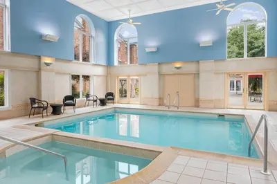 a pool in a large room with blue walls and windows at Residence Inn by Marriott West Orange in West Orange