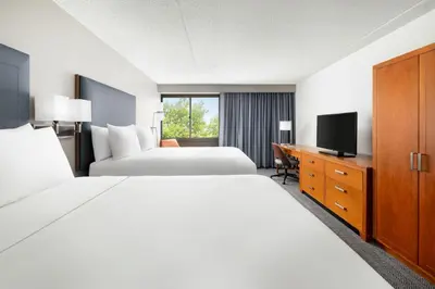 a hotel room with two beds and a television at Courtyard Montvale in Montvale