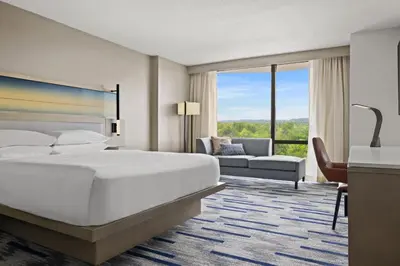 a hotel room with a large bed and a couch at Marriott Saddle Brook in Saddle Brook