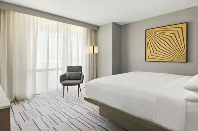 a bedroom with a bed and a chair and a window at Marriott Saddle Brook in Saddle Brook