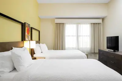 a hotel room with two beds and a flat screen tv at Residence Inn New Rochelle in New Rochelle
