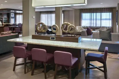 a lobby with a bar with chairs and a salon at Courtyard Newburgh Stewart Airport in Newburgh