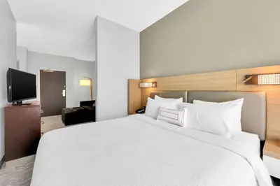 a hotel room with a large bed and a tv at SpringHill Suites by Marriott Tarrytown Westchester County in Tarrytown