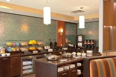 a restaurant with a counter with food on it at SpringHill Suites by Marriott Tarrytown Westchester County in Tarrytown