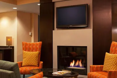 a living room with a fireplace and a flat screen tv at SpringHill Suites by Marriott Tarrytown Westchester County in Tarrytown