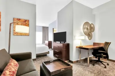 a hotel room with a bed and a desk with a computer at SpringHill Suites by Marriott Tarrytown Westchester County in Tarrytown