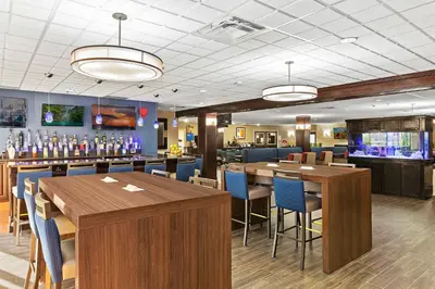 a restaurant with tables and chairs and a bar at Comfort Inn Syosset-Long Island in Syosset