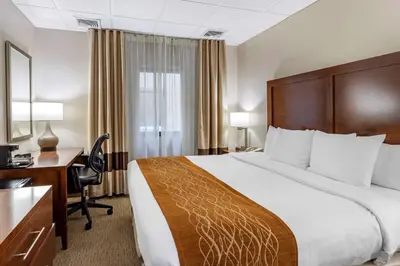 a hotel room with a large bed and a desk at Comfort Inn Syosset-Long Island in Syosset