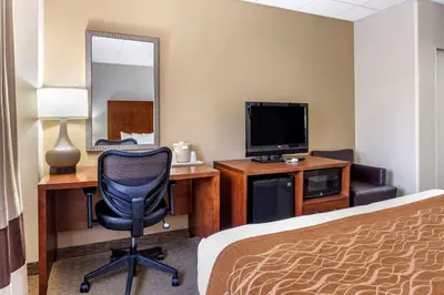 a hotel room with a bed and a desk and a chair at Comfort Inn Syosset-Long Island in Syosset