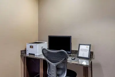a desk with a computer and a monitor and a chair at Comfort Inn Syosset-Long Island in Syosset