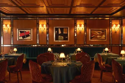 a dining room with tables and chairs and lights at The Mark New York in New York
