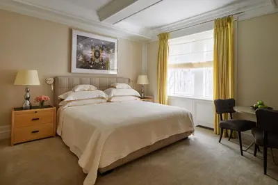 a bedroom with a bed and a desk and a window at The Mark New York in New York