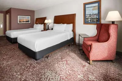 a hotel room with two beds and a chair at Hilton Garden Inn Milford in Milford
