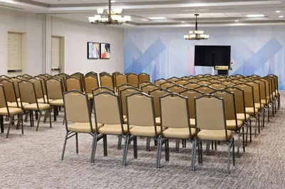 a row of chairs in a room with a tv at Hilton Garden Inn Milford in Milford