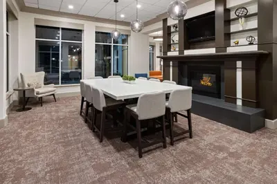 a dining room with a table and a fireplace at Hilton Garden Inn Milford in Milford