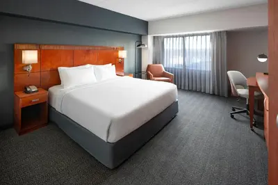 a hotel room with a bed and a desk and chairs at Courtyard Shelton in Shelton
