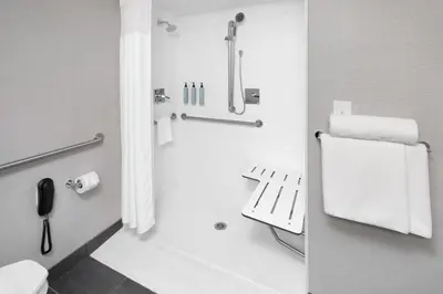 a bathroom with a shower and a toilet and towels at Courtyard Shelton in Shelton