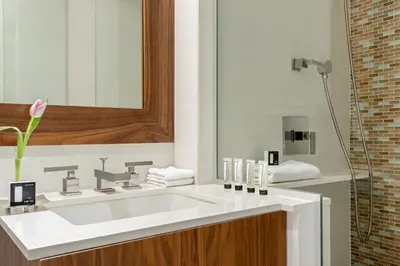 a bathroom with a white sink and a shower at The Gotham Hotel in New York