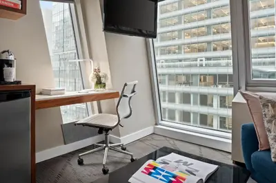 a room with a desk and a chair and a window at The Gotham Hotel in New York