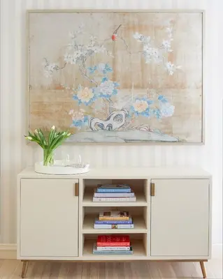 a white cabinet in a living room with a painting at 33 Main in Lenox