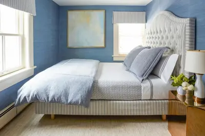 a bedroom with a bed with blue walls and windows at 33 Main in Lenox