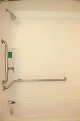a bathroom with a bath tub with a handicap rail at Courtyard Waterbury Downtown in Waterbury