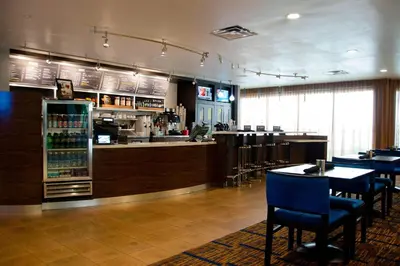 a restaurant with a bar and tables and chairs at Courtyard Waterbury Downtown in Waterbury