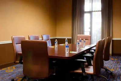 a conference room with a wooden table and chairs at Courtyard Waterbury Downtown in Waterbury