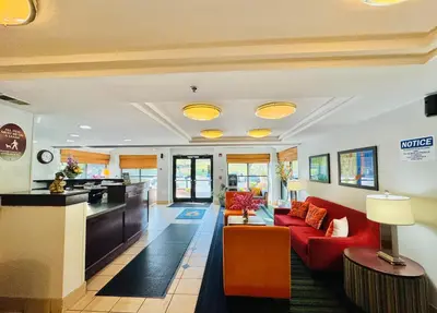 a living room with red couches and a kitchen at Motel 6-Milford, CT in Milford