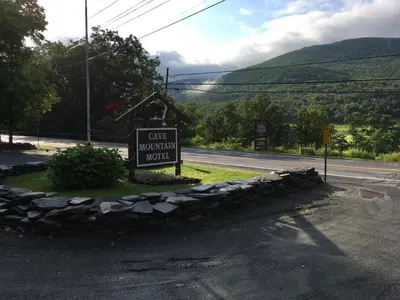 a sign for a car museum hotel on the side of a road at Cave Mountain Motel in Windham
