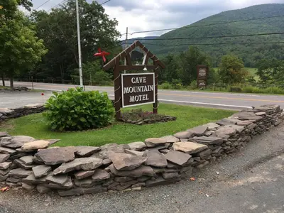 a sign for a cave mountain motel on the side of a road at Cave Mountain Motel in Windham