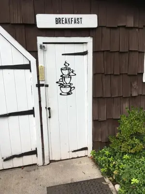 a white garage door with a sign that reads break least at Cave Mountain Motel in Windham