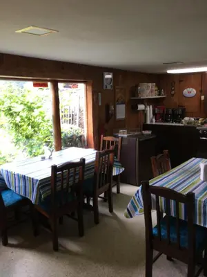 a kitchen and dining room with two tables and chairs at Cave Mountain Motel in Windham