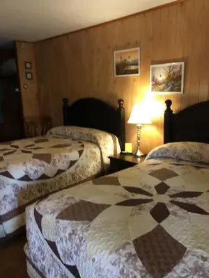 a hotel room with two beds and a lamp at Cave Mountain Motel in Windham