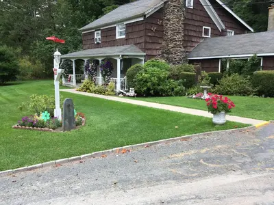a house with a gazebo and flowers in the yard at Cave Mountain Motel in Windham