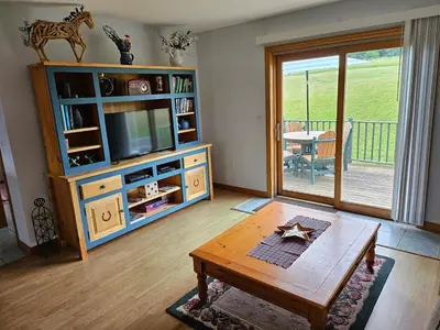 a living room with a tv and a table at Clover Hill Farm & Country Inn in Williamstown