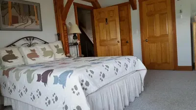a bedroom with a bed and two wooden doors at Clover Hill Farm & Country Inn in Williamstown