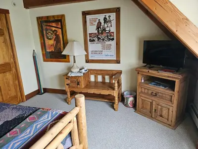 a bedroom with a bed and a television and a table at Clover Hill Farm & Country Inn in Williamstown