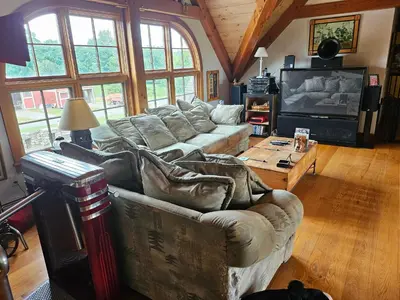 a living room with a couch and a tv at Clover Hill Farm & Country Inn in Williamstown