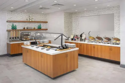 a large kitchen with a counter top with a buffet at Hilton Garden Inn Westchester Dobbs Ferry in Dobbs Ferry