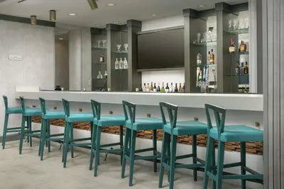 a bar with blue chairs in a hotel room at Hilton Garden Inn Westchester Dobbs Ferry in Dobbs Ferry